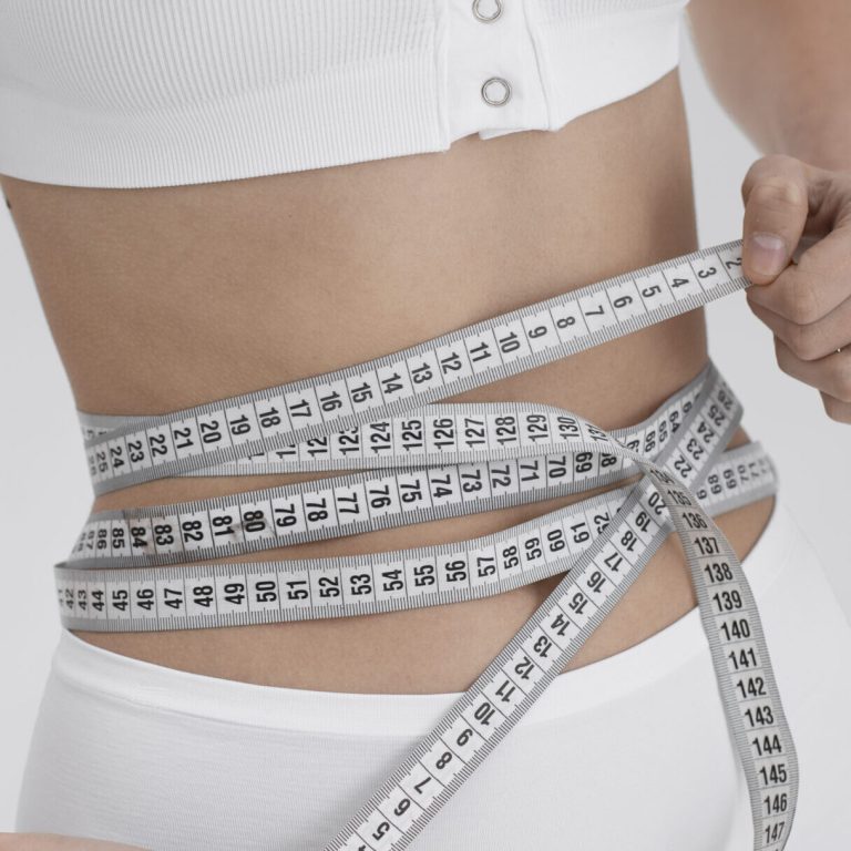 young-woman-with-eating-disorder-using-tape-measure